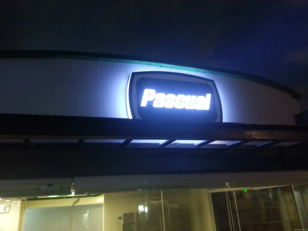 Illuminated signage for Pascual above building entrance at night in Ortigas, Metro Manila by M&G Global Ads.