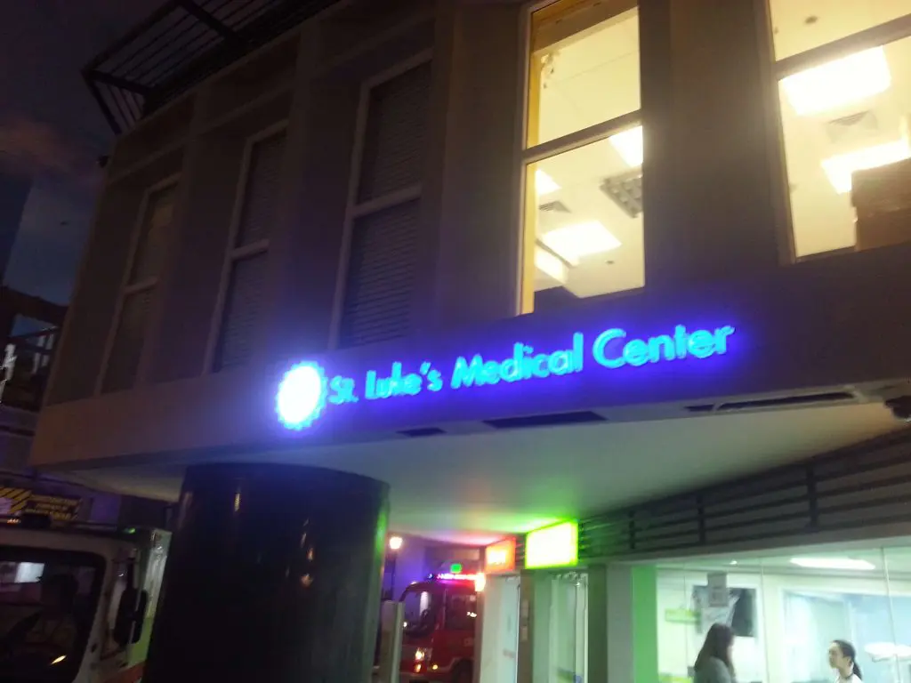 St. Lukes Medical Center blue LED signage on building exterior at night in BGC, with lit entrance, by M&G Global Ads.