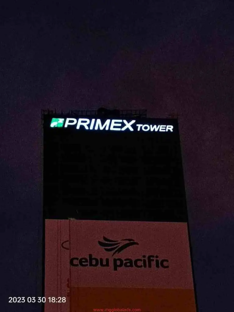 Illuminated PRIMEX TOWER building signage and Cebu Pacific ad in Ortigas at night, timestamped 2023-03-30, by M&G Global Ads.