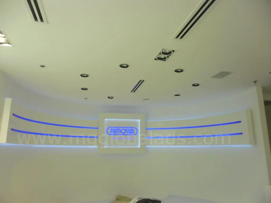 Illuminated building signage for RIMOWA on a modern white wall in Makati with blue accents, by M&G Global Ads.