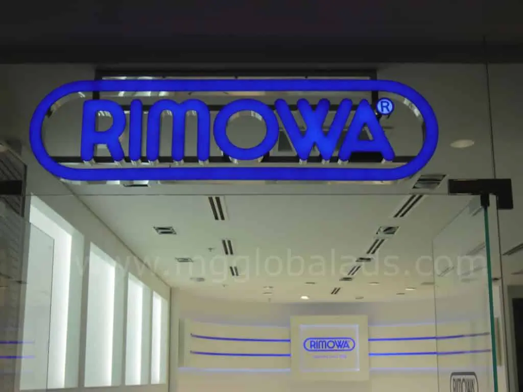 Illuminated acrylic RIMOWA signage at store entrance in Makati with glass reflections, by M&G Global Ads.