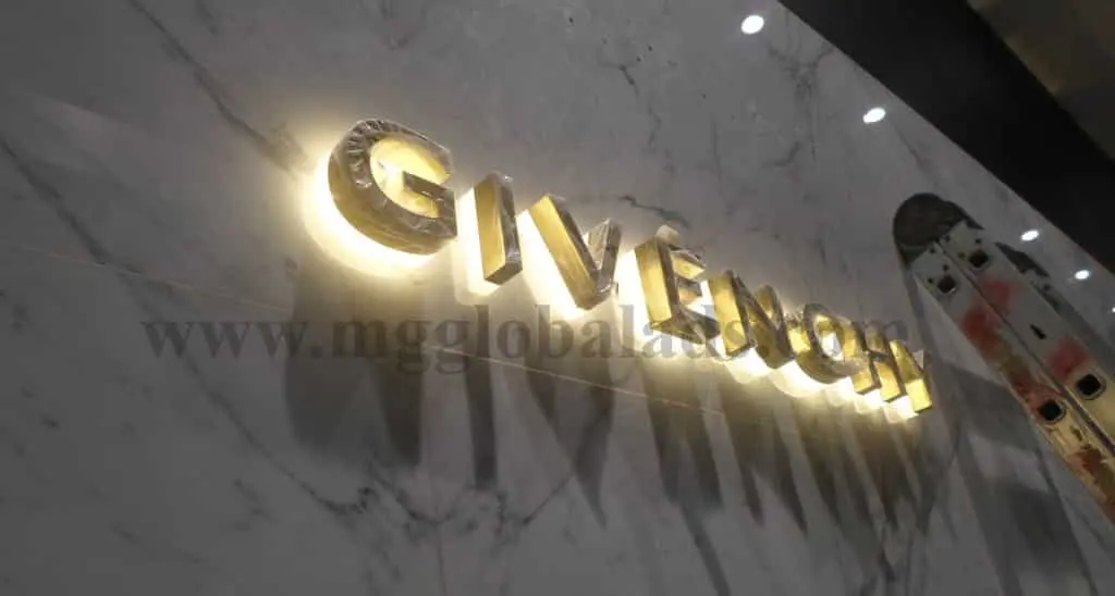 GIVENCHY illuminated pylon signage on marble wall, glowing gold letters, Makati location by M&G Global Ads.