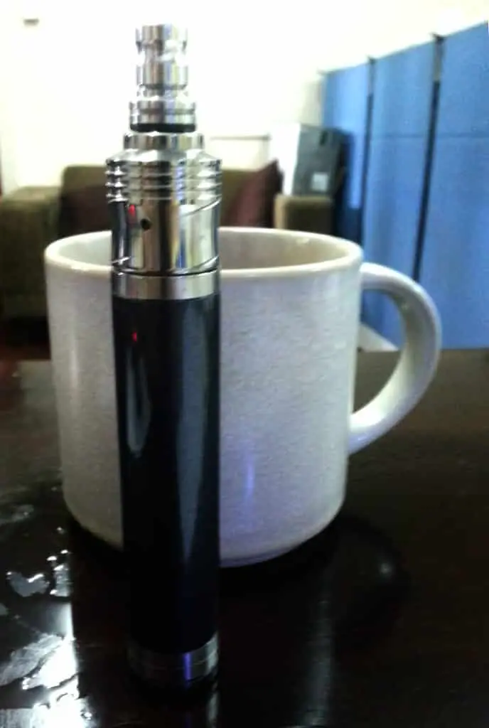 Black and silver vape with white mug, LED signage display near sofa and blue dividers in Makati by M&G Global Ads.