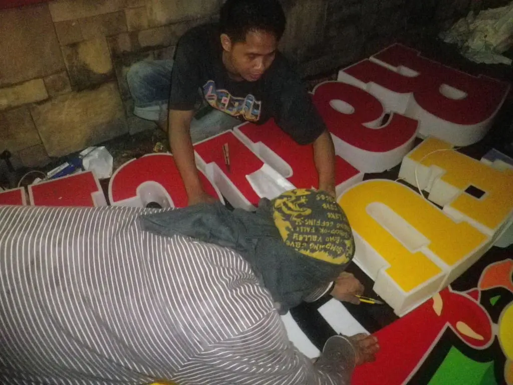 3D outdoor signage assembly in Quezon City by skilled makers; large colorful letters being set up on ground by M&G Global Ads.
