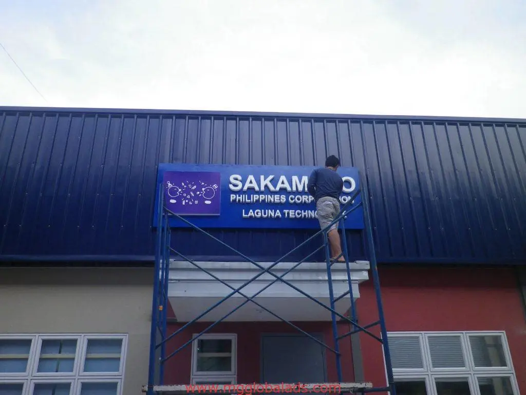 Outdoor building signage installation for SAKAMOTO PHILIPPINES CORP. in Makati with blue, white, red panels by M&G Global Ads.