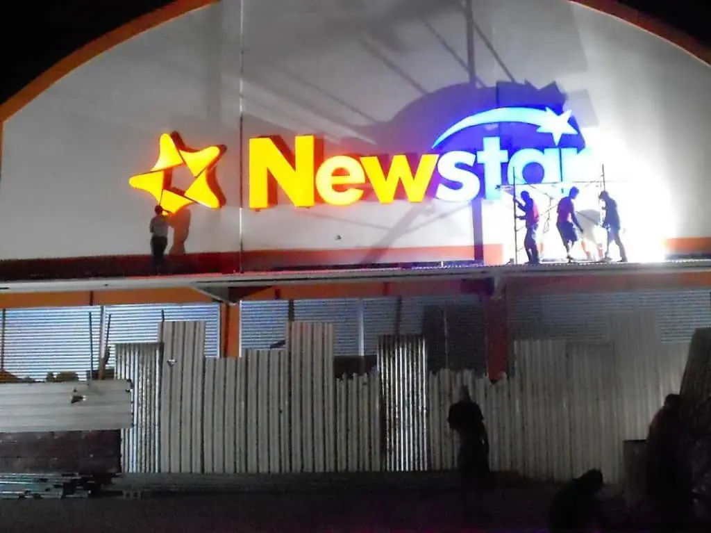 Newstar LED signage installation with yellow star logo and orange text at night in Quezon City by M&G Global Ads.