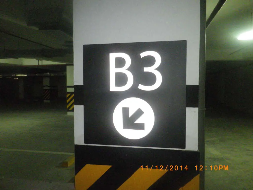 LED indoor parking signage B3 with down-left arrow at Quezon City parking garage, timestamped. By M&G Global Ads.