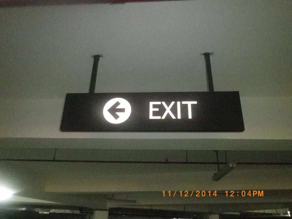Overhead parking garage exit signage with left arrow, timestamped 11/12/2014, Quezon City location by M&G Global Ads.