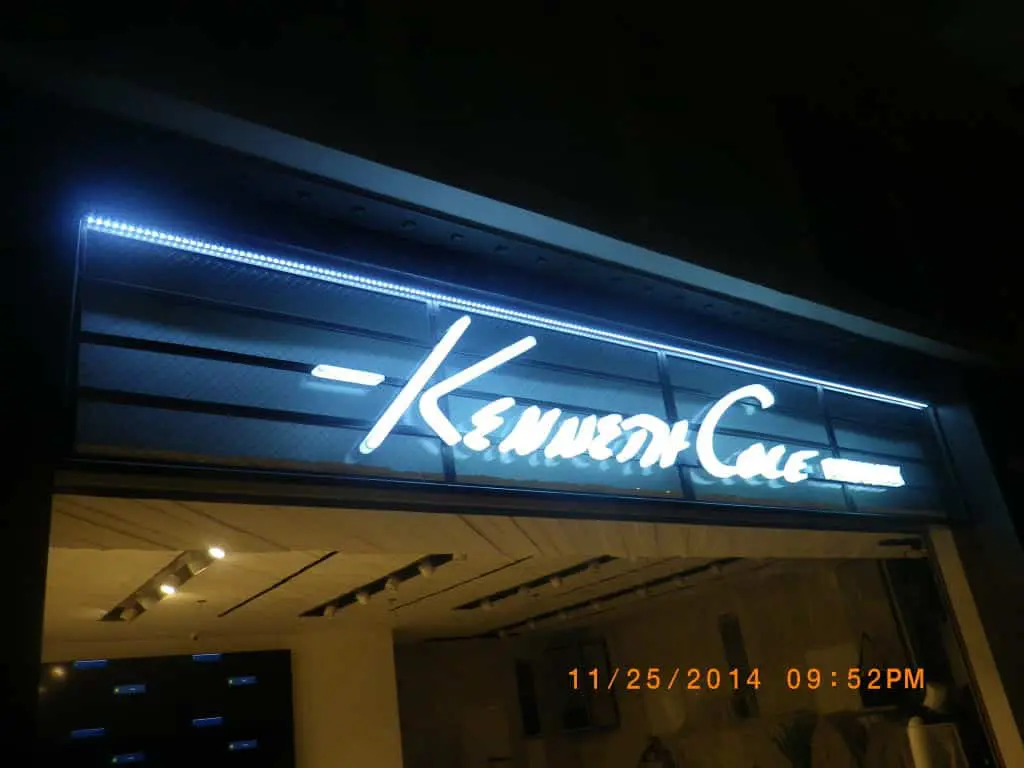 Kenneth Cole LED signage with white illuminated text at night in Makati, store interior visible. By M&G Global Ads.