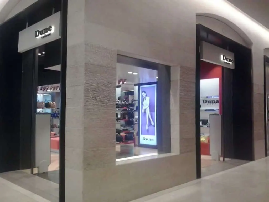 Dune London illuminated building signage at mall entrance in Makati, large ad and window display viewed, by M&G Global Ads.