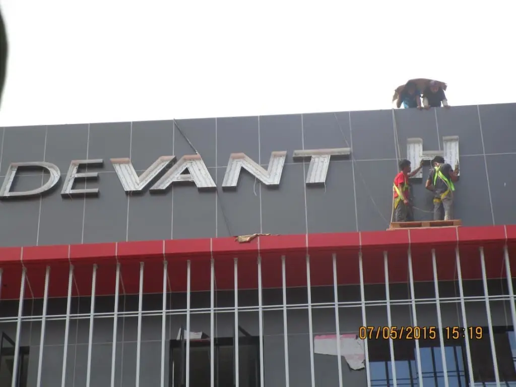 DEVANT outdoor building signage installation in Quezon City by M&G Global Ads. Workers on scaffolding, July 5, 2015.
