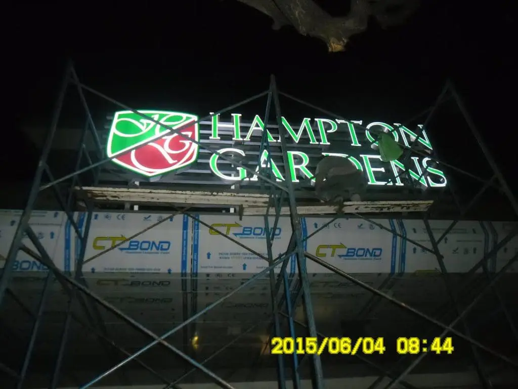 Neon LED signage for Hampton Gardens being installed at night in Pasig by M&G Global Ads.