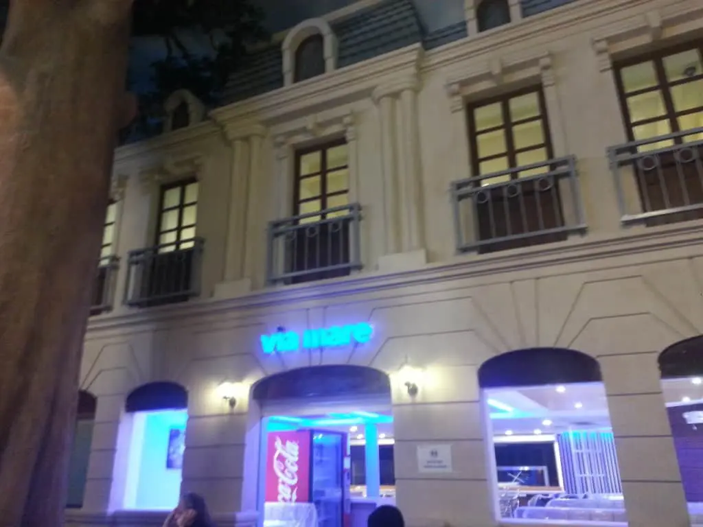 Via Mare neon metallic signage on classic building facade, Coca-Cola vending machine, Makati exterior at night by M&G Global Ads.