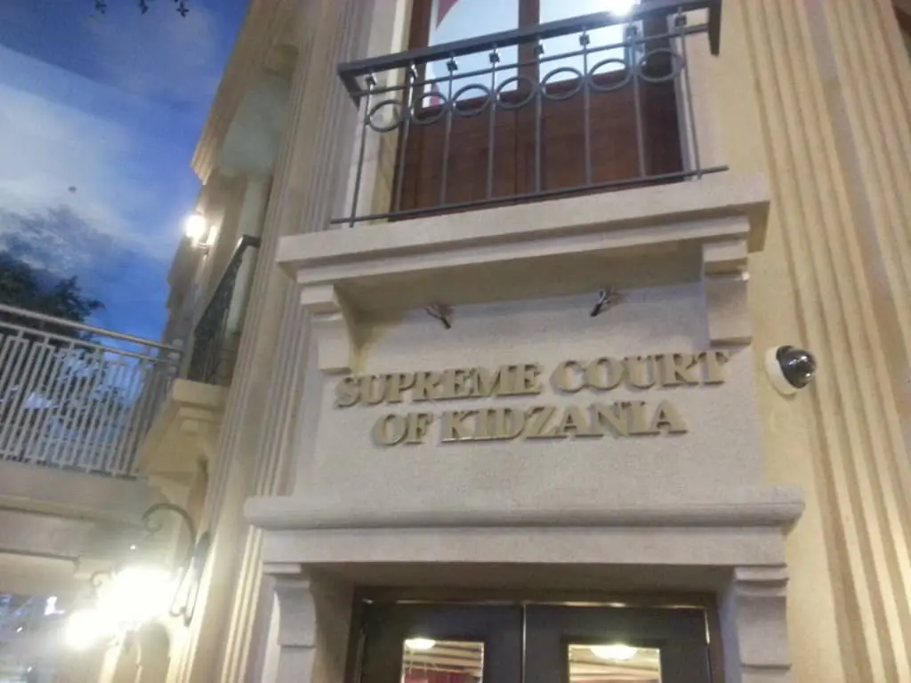 Acrylic Supreme Court of Kidzania signage on beige facade in BGC, above double doors with columns and balcony by M&G Global Ads.