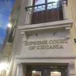 Acrylic Supreme Court of Kidzania signage on beige facade in BGC, above double doors with columns and balcony by M&G Global Ads.