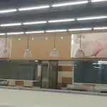 Supermarket metallic signage with raw chicken images in Ortigas, glass display cases, hanging lights by M&G Global Ads.