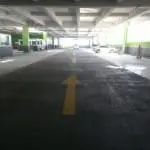 Acrylic road signage in Makati: yellow three-way intersection arrows on concrete near motorcycles, by M&G Global Ads.