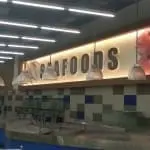 Illuminated acrylic SEAFOODS supermarket signage in Makati, with counters, pendant lights, tanks—by M&G Global Ads.