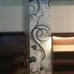 Acrylic signage display near white pillar with green vine design and wooden shelves in a Makati interior by M&G Global Ads.