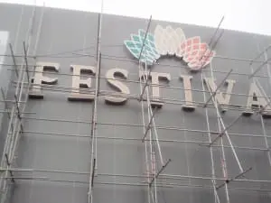Acrylic FESTIVA building signage with colorful petals, installation in progress in Pasig, by M&G Global Ads.