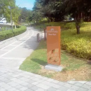 Orange metallic park entrance signage for Festival River Park in Makati, green park background, by M&G Global Ads.