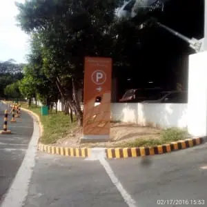 Orange LED parking signage for Asian Zapote Steel Parking in Mandaluyong beside cars and road markers, by M&G Global Ads.