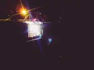 Boat with FESTIVAL LED signage docked at night in Makati, glowing yellow and purple. LED boat signage by M&G Global Ads.