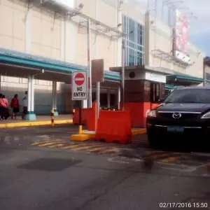 Outdoor building signage display with black Mazda SUV, security booth, and barricades in Makati by M&G Global Ads.