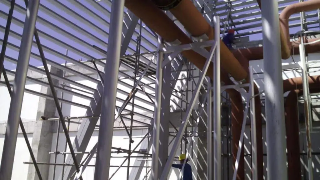 Billboard signage installation for a client in Makati with scaffolding, beams, and two workers on site by M&G Global Ads.