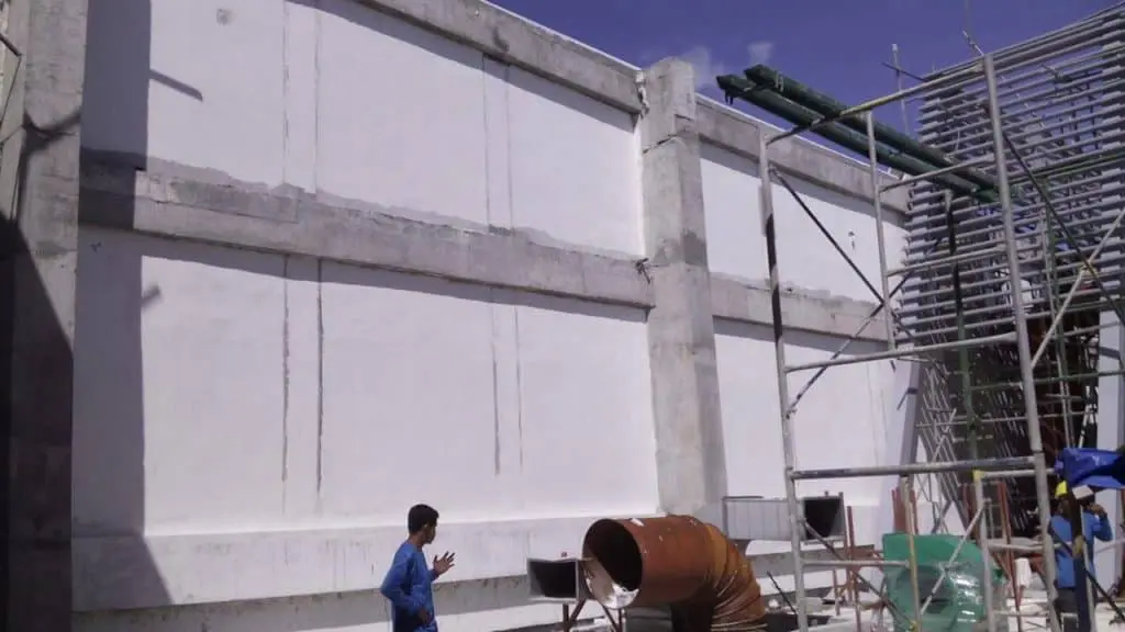 Billboard installation with outdoor signage in Makati; person in blue shirt, scaffolding, beams, clear sky by M&G Global Ads.