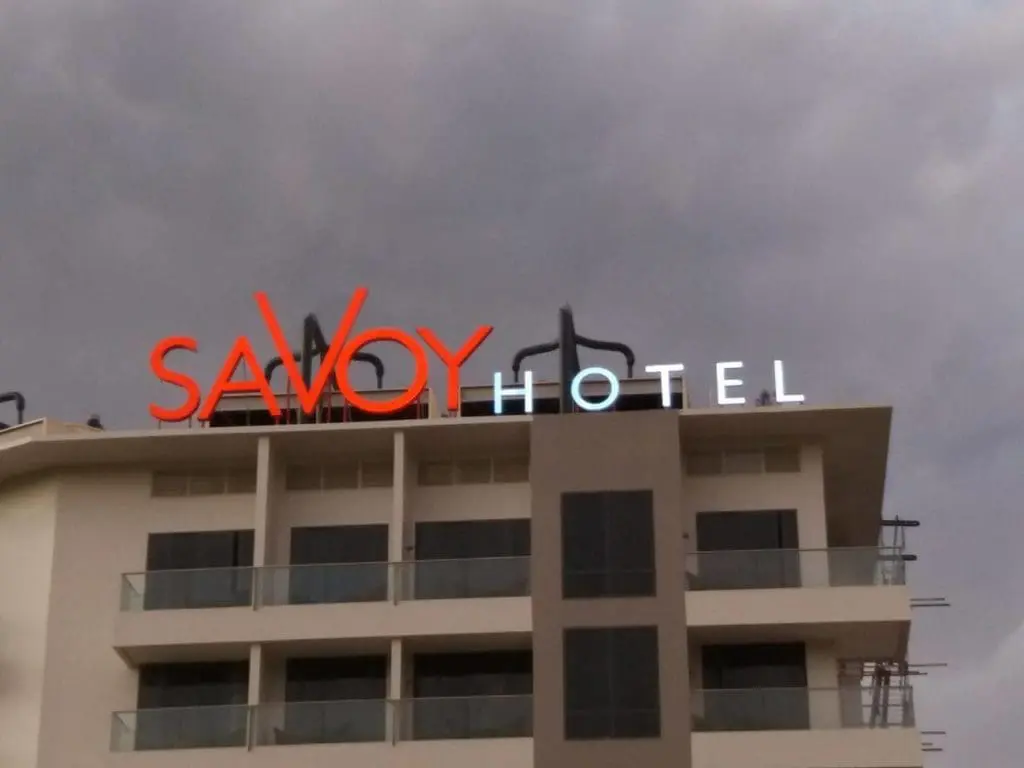 LED hotel roof signage for SAVOY HOTEL in Makati, with glass balconies and cloudy sky, by M&G Global Ads.