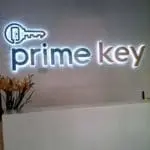 Illuminated acrylic indoor office signage for Prime Key in Makati, with flowers on counter by M&G Global Ads.