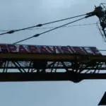 Billboard signage for PARAVISIBLE held by crane in Makati, blue and red design on side, by M&G Global Ads.