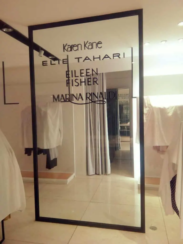 Acrylic mirror signage with designer names at a clothing store in Makati, with racks and fitting rooms. By M&G Global Ads.