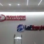 Metallic office signage for Feliciano Customs Brokerage and LeFreight Forwarder in Quezon City by M&G Global Ads. Ladder visible.