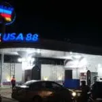 USA 88 gas station metallic illuminated signage with cars and bikes at night in Quezon City, by M&G Global Ads.