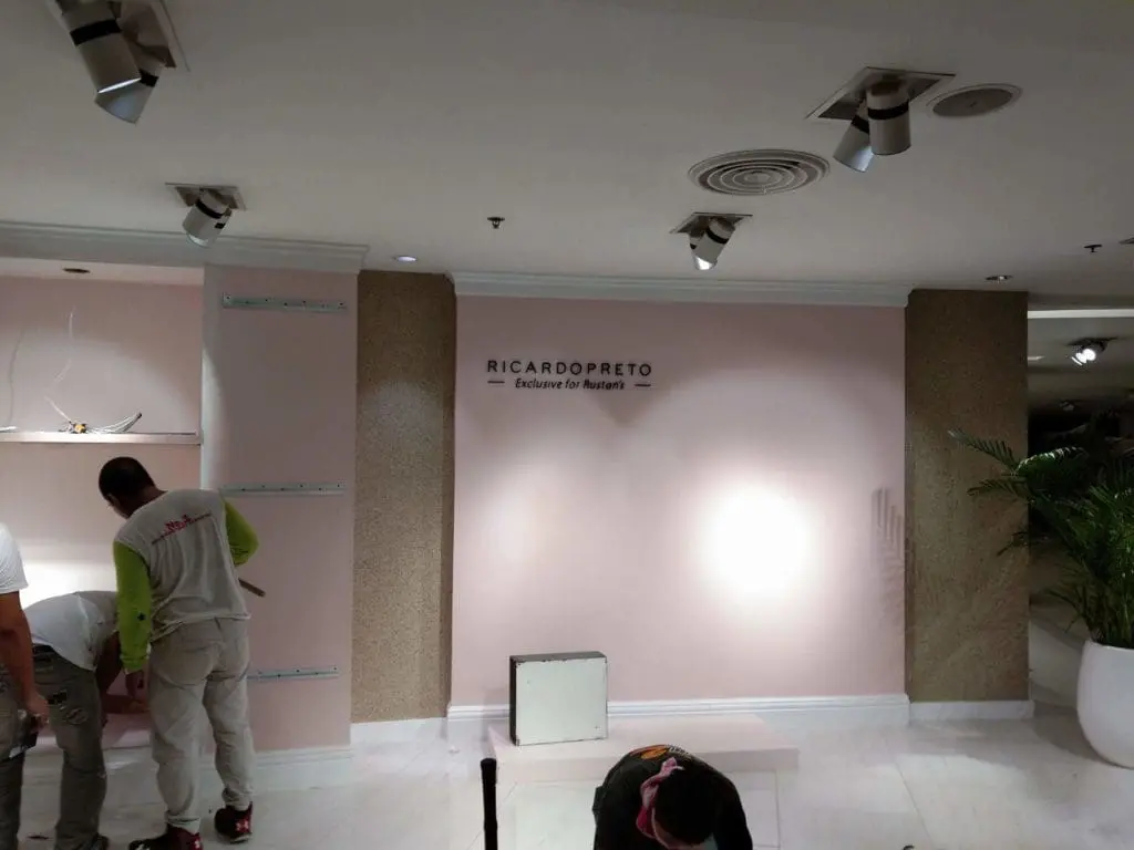 Metallic store signage for Rustan’s client installed in Makati, with workers and tools visible. By M&G Global Ads.