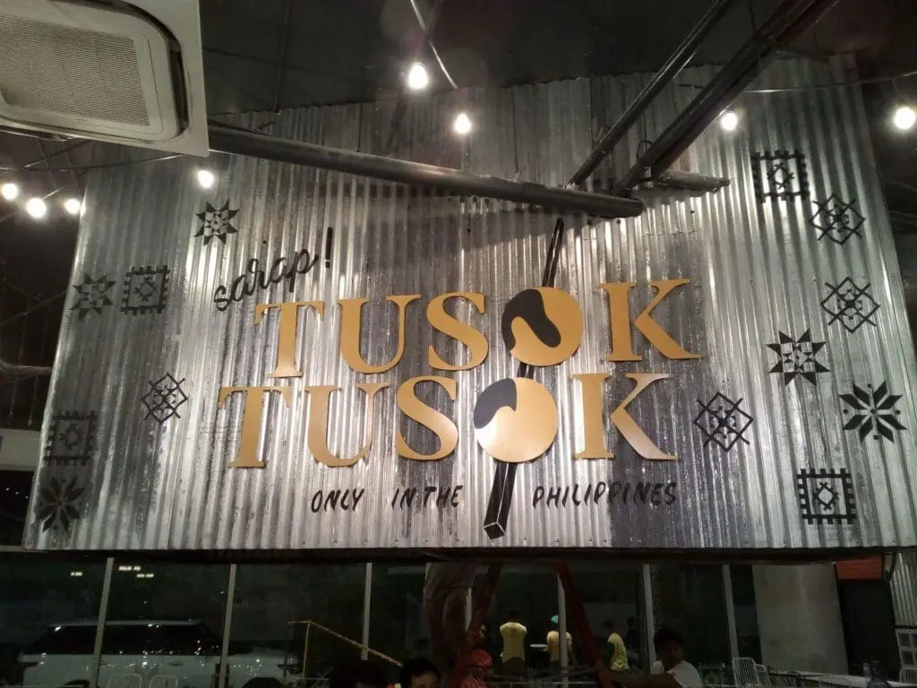 Restaurant signage for Tusok Tusok in Quezon City on corrugated metal wall with skewer art, by M&G Global Ads.