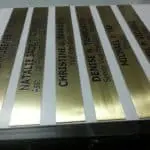 Gold office signage with engraved job titles on metallic plates for corporate clients in Ortigas by M&G Global Ads.