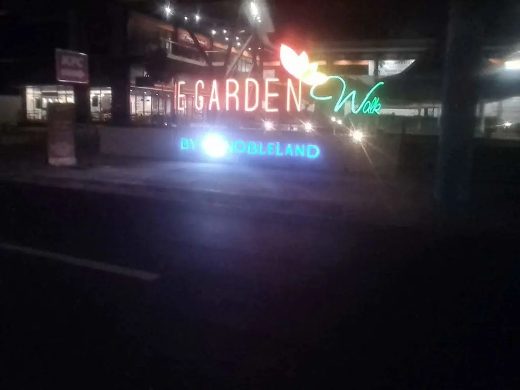Neon LED signage for Nobleland’s Garden Walk in Makati, with colorful leaf design accents at night, by M&G Global Ads.