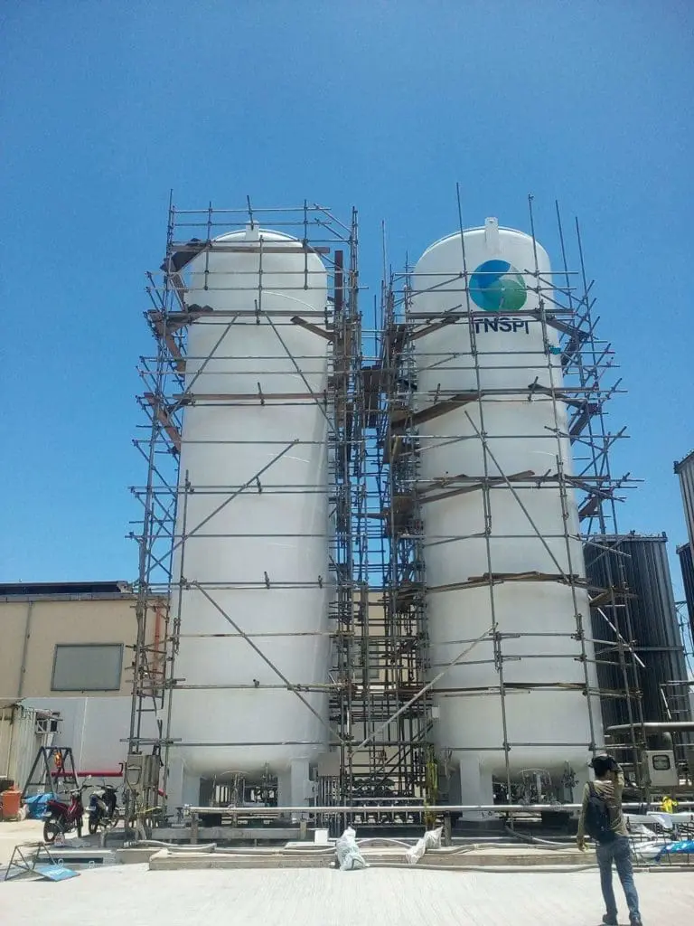 Metallic signage with INSPI logo on two white storage tanks in Mandaluyong by M&G Global Ads.