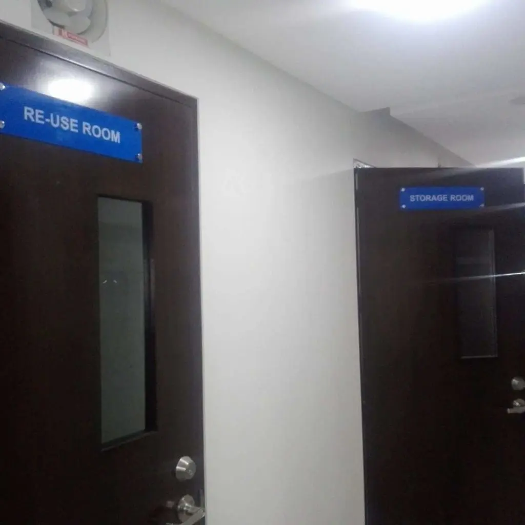 Acrylic door signage for RE-USE ROOM and STORAGE ROOM on dark brown doors in Mandaluyong hallway by M&G Global Ads.