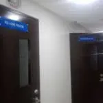 Acrylic door signage for RE-USE ROOM and STORAGE ROOM on dark brown doors in Mandaluyong hallway by M&G Global Ads.