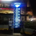 LED signage directory at Greenhills in San Juan shows parking levels P1–P7 and zones; people nearby, restaurant behind. by M&G Global Ads.