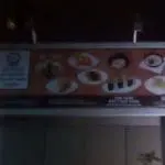 Blurry billboard signage for Japanese restaurant with sushi plates at night in Makati, text unreadable, by M&G Global Ads.