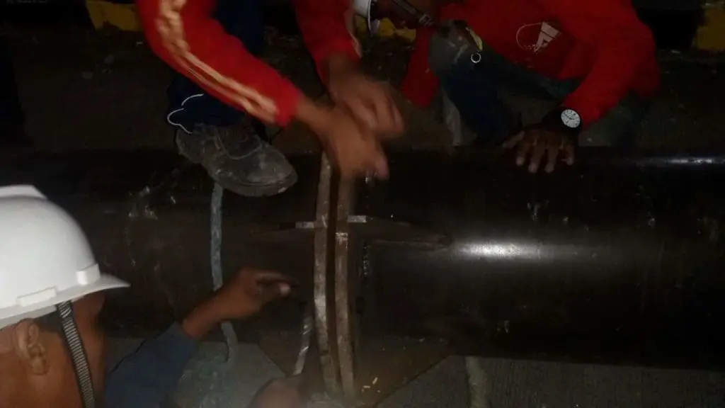 LED billboard signage installation in Makati at night by three workers in safety gear, by M&G Global Ads.