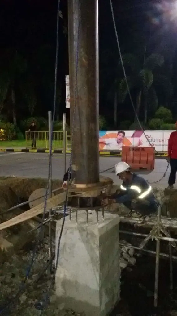 Billboard installation for client in Makati, with workers securing signage at night, by M&G Global Ads.