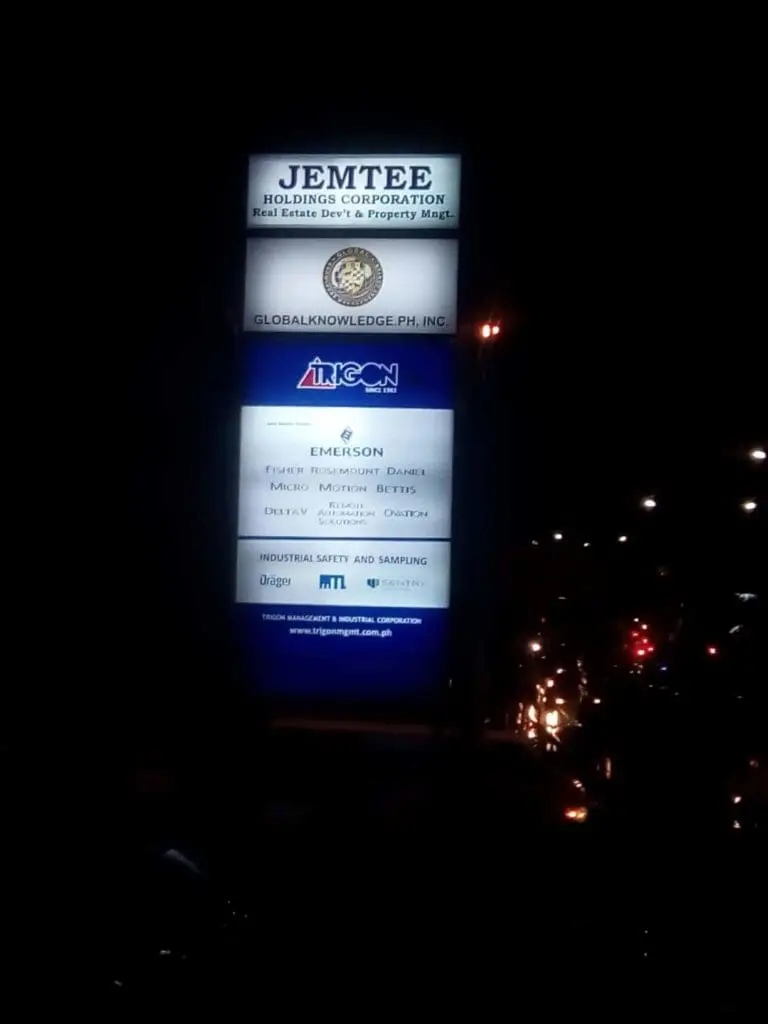 LED pylon signage for Jemtee Holdings, Global Knowledge, Emerson at night in Ortigas, glowing beside street lights by M&G Global Ads.
