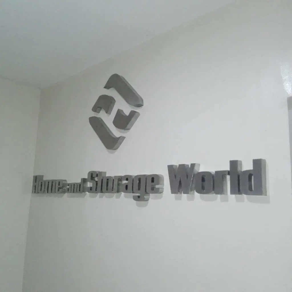 Silver 3D stainless signage for Home and Storage World with geometric logo in a Makati business interior by M&G Global Ads.
