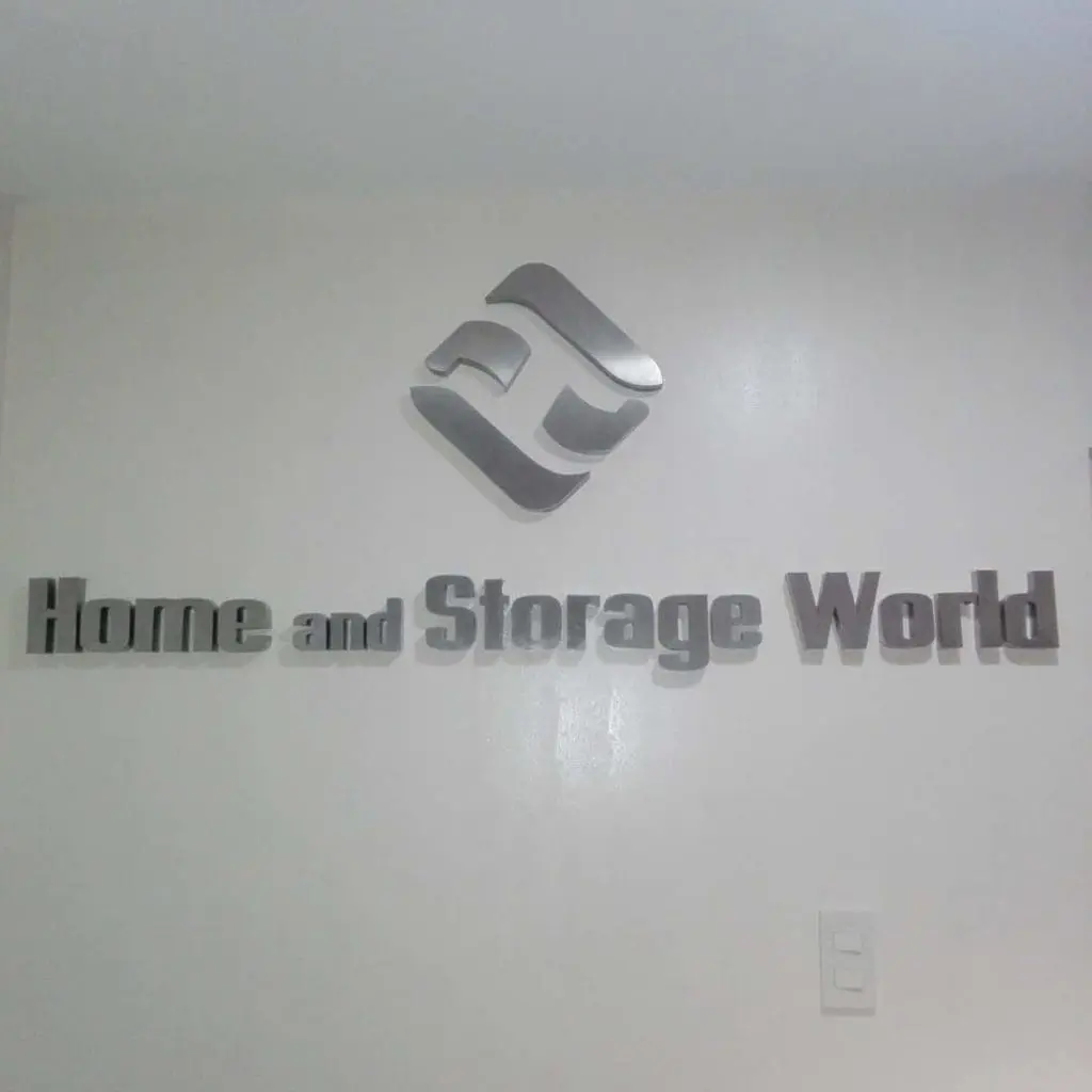 Silver 3D acrylic signage for Home and Storage World in Makati, featuring geometric logo on white wall by M&G Global Ads.